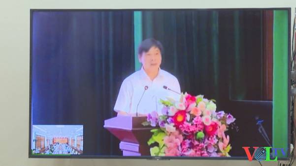 A person standing at a podium with a microphone and flowers

AI-generated content may be incorrect.