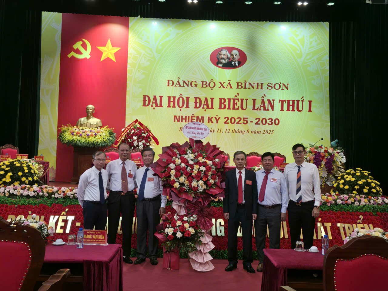 A group of men standing in front of a large banner
AI-generated content may be incorrect.